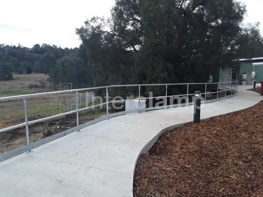 Interclamp DDA modular handrailing installed along a ramp, providing optimal safety and stability, designed to meet Australian handrail standards with smooth, continuous handrails.